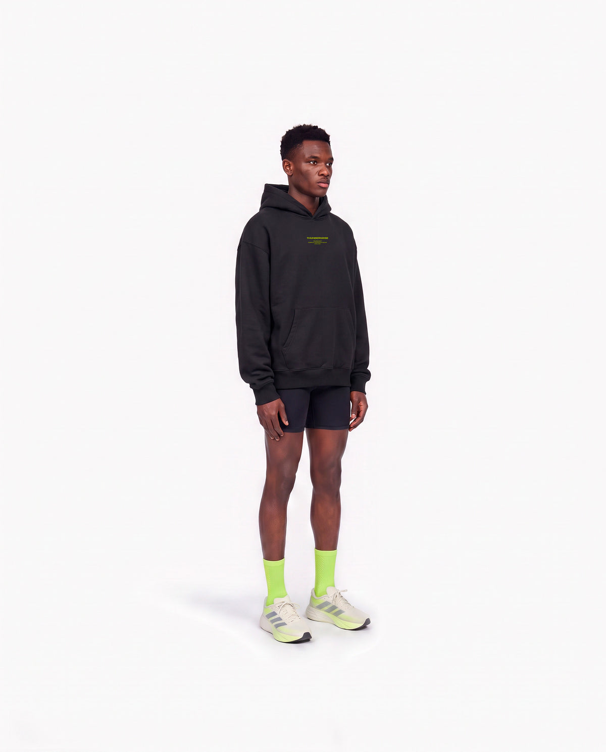 Model wearing the Brick by Brick oversize hoodie in black — three-quarter view showing the oversize fit — View 3