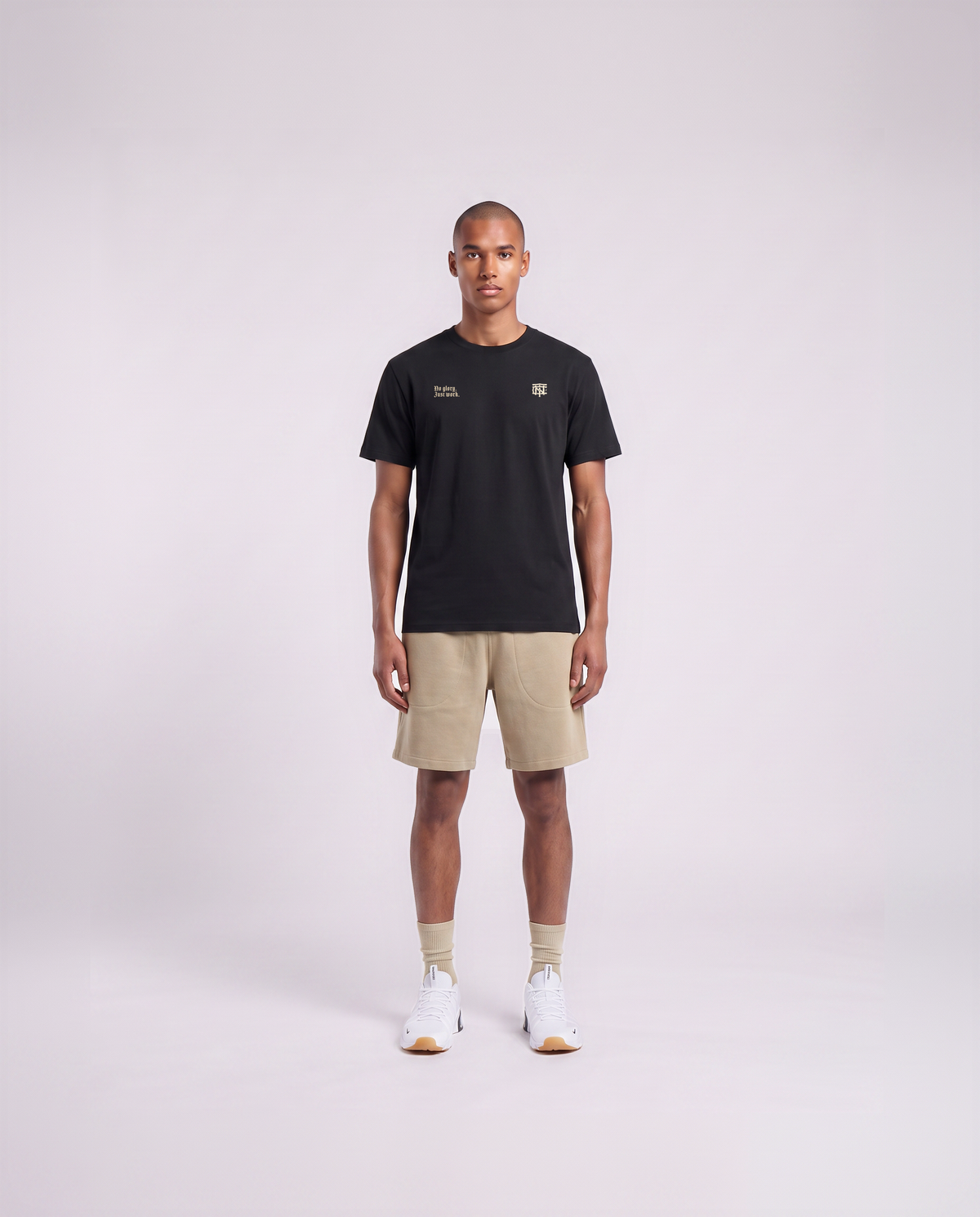 Model wearing the No Glory Just Work t-shirt in black — front view with the left-chest NO GLORY JUST WORK wordmark and the right-chest Thundernoise monogram in sand — View 2