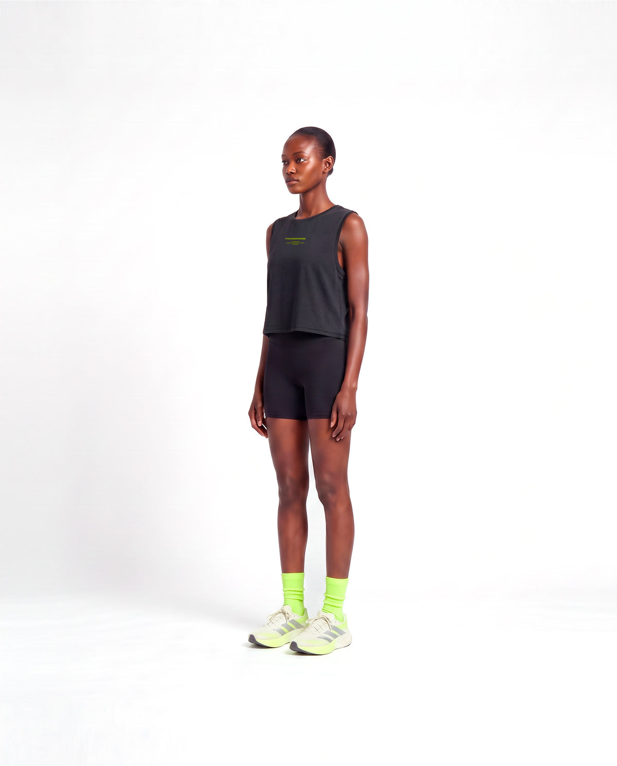 Model wearing the Brick by Brick cropped tank top in black — three-quarter view showing the cropped fit — View 3
