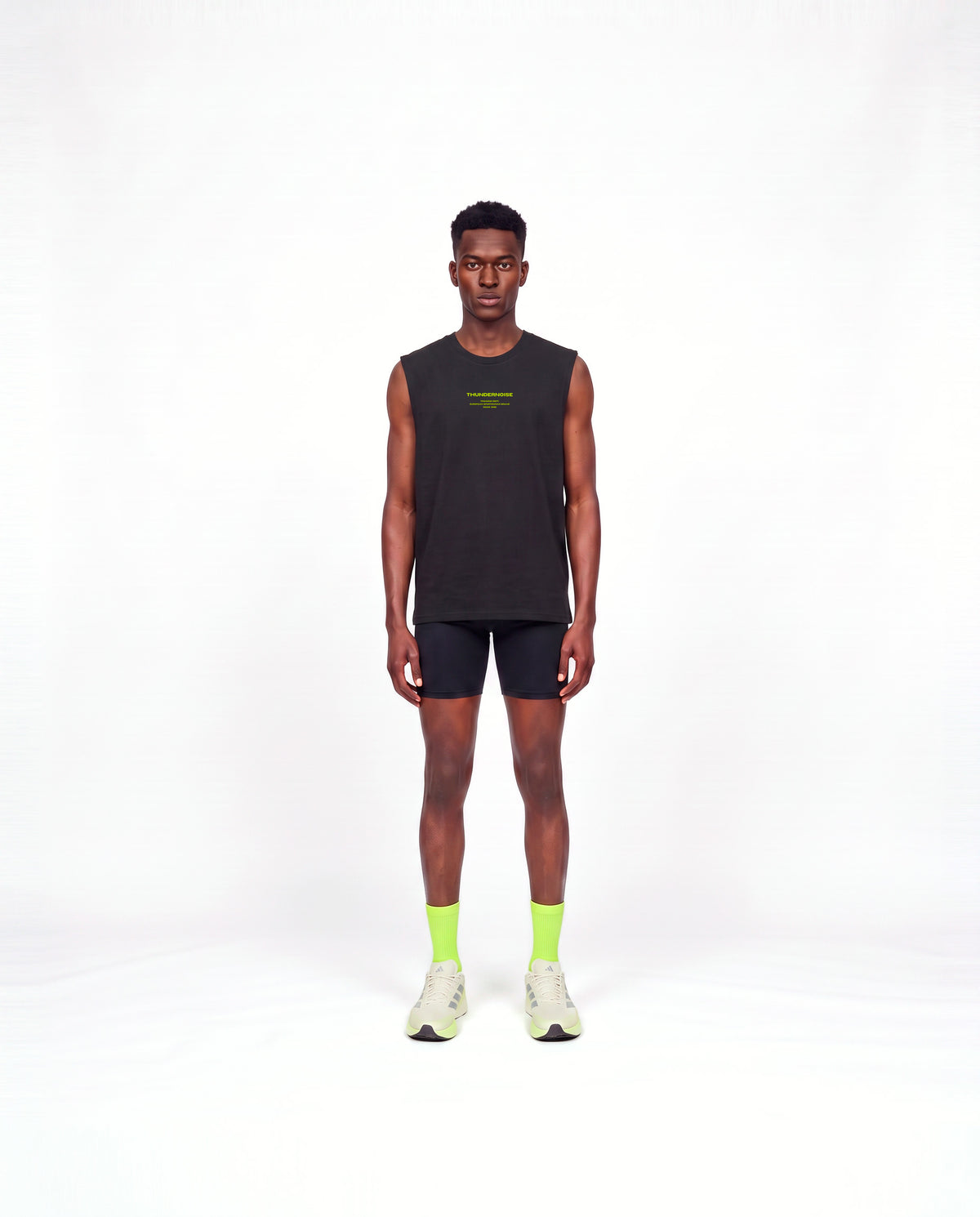 Model wearing the Brick by Brick tank top in black — front view with the THUNDERNOISE TRAINING DEPT block centred on the chest in lime green — View 2
