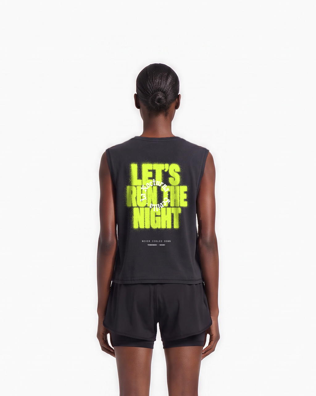 Model wearing the Let's Run the Night cropped tank top in black — back view, close crop on LET'S RUN THE NIGHT sprayed in electric lime around the La Nocturna Sevilla seal — View 7
