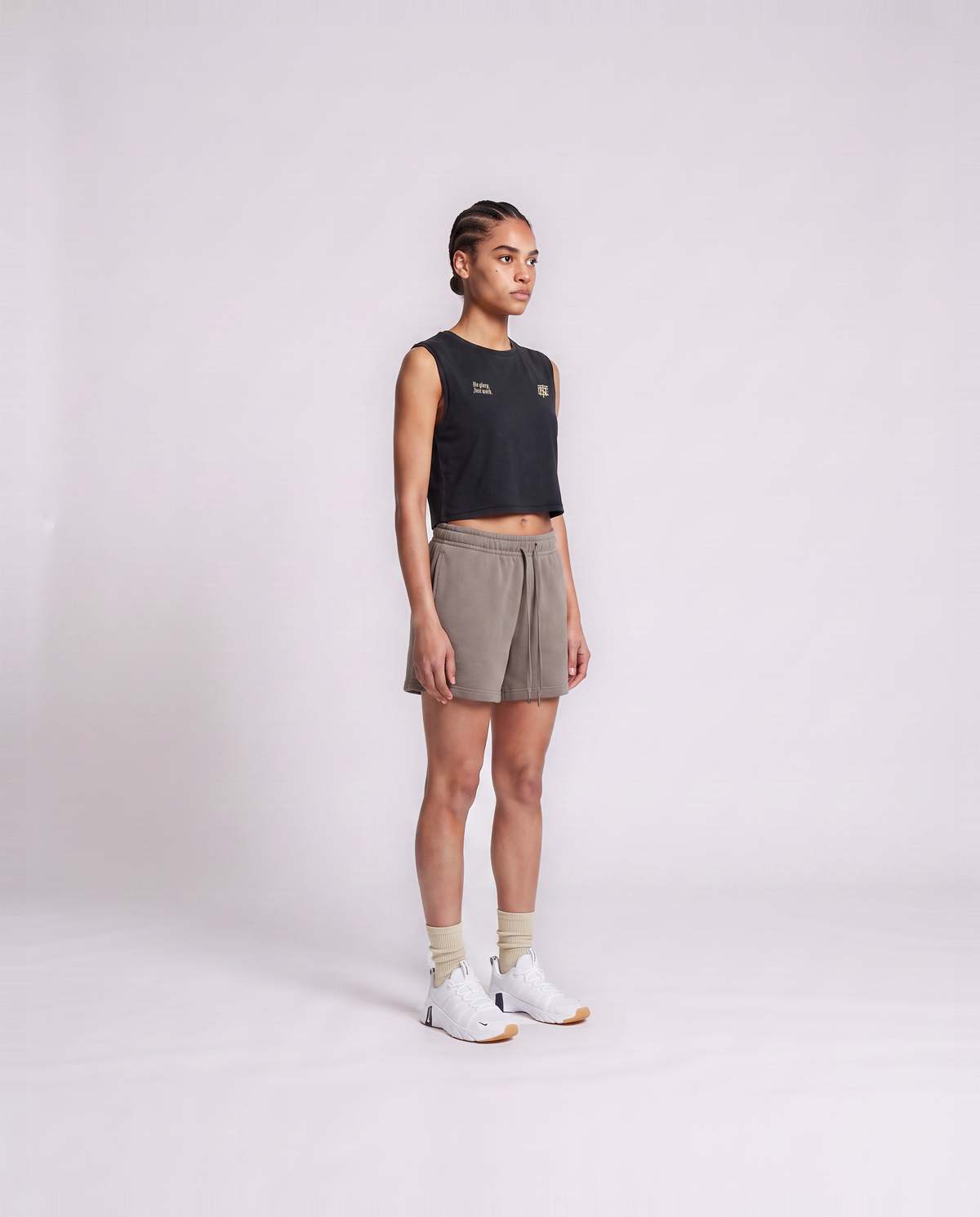 Model wearing the No Glory Just Work cropped tank top in black — three-quarter view showing the cropped fit — View 3
