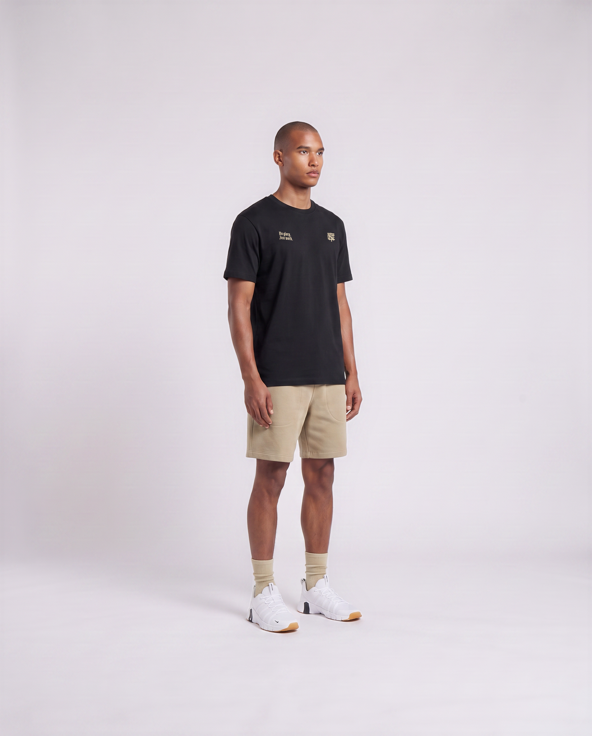 Model wearing the No Glory Just Work t-shirt in black — three-quarter view showing the regular fit — View 3
