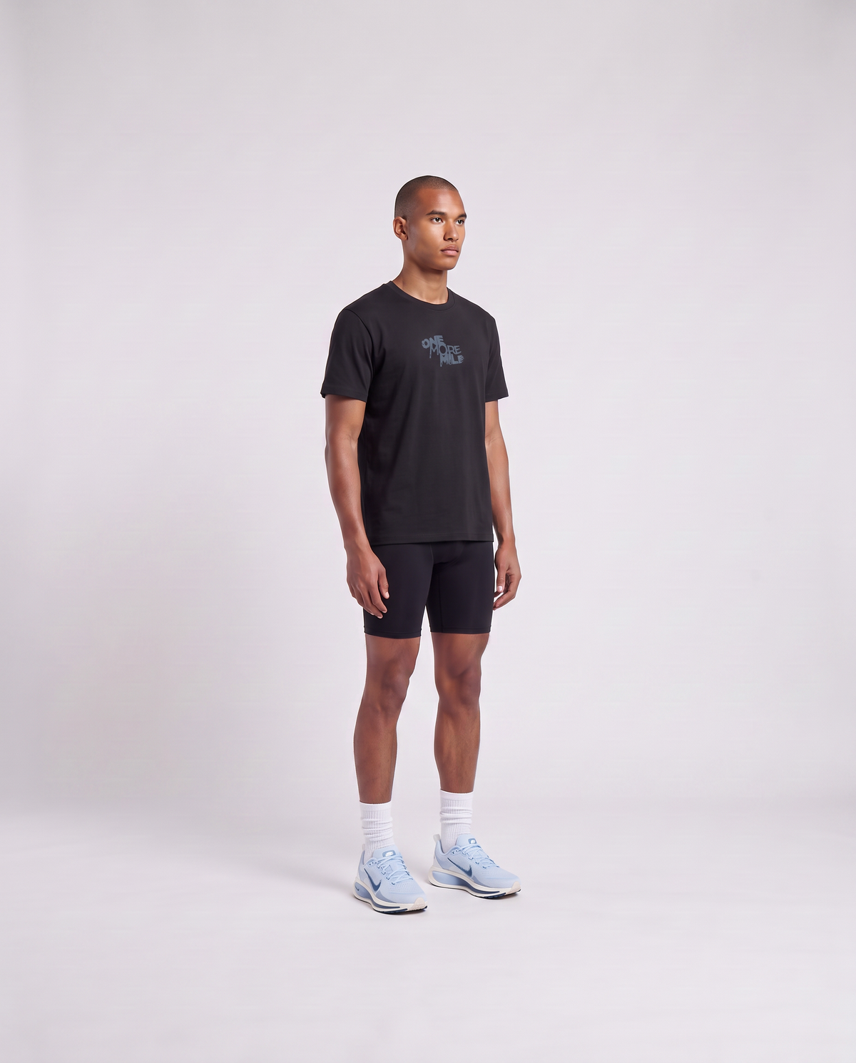 Model wearing the One More Mile t-shirt in black — three-quarter view showing the regular fit