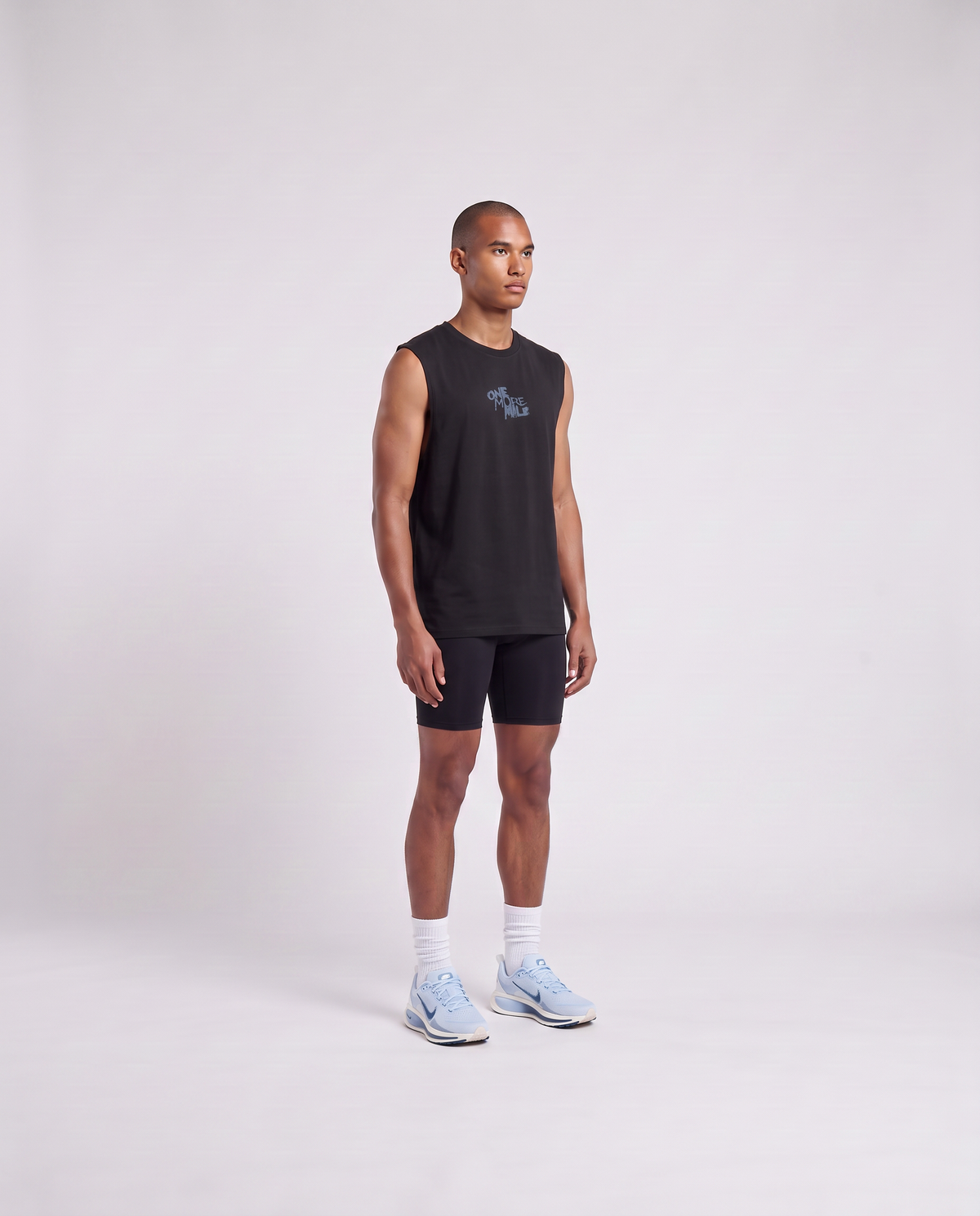 Model wearing the One More Mile tank top in black — three-quarter view showing the regular fit — View 3
