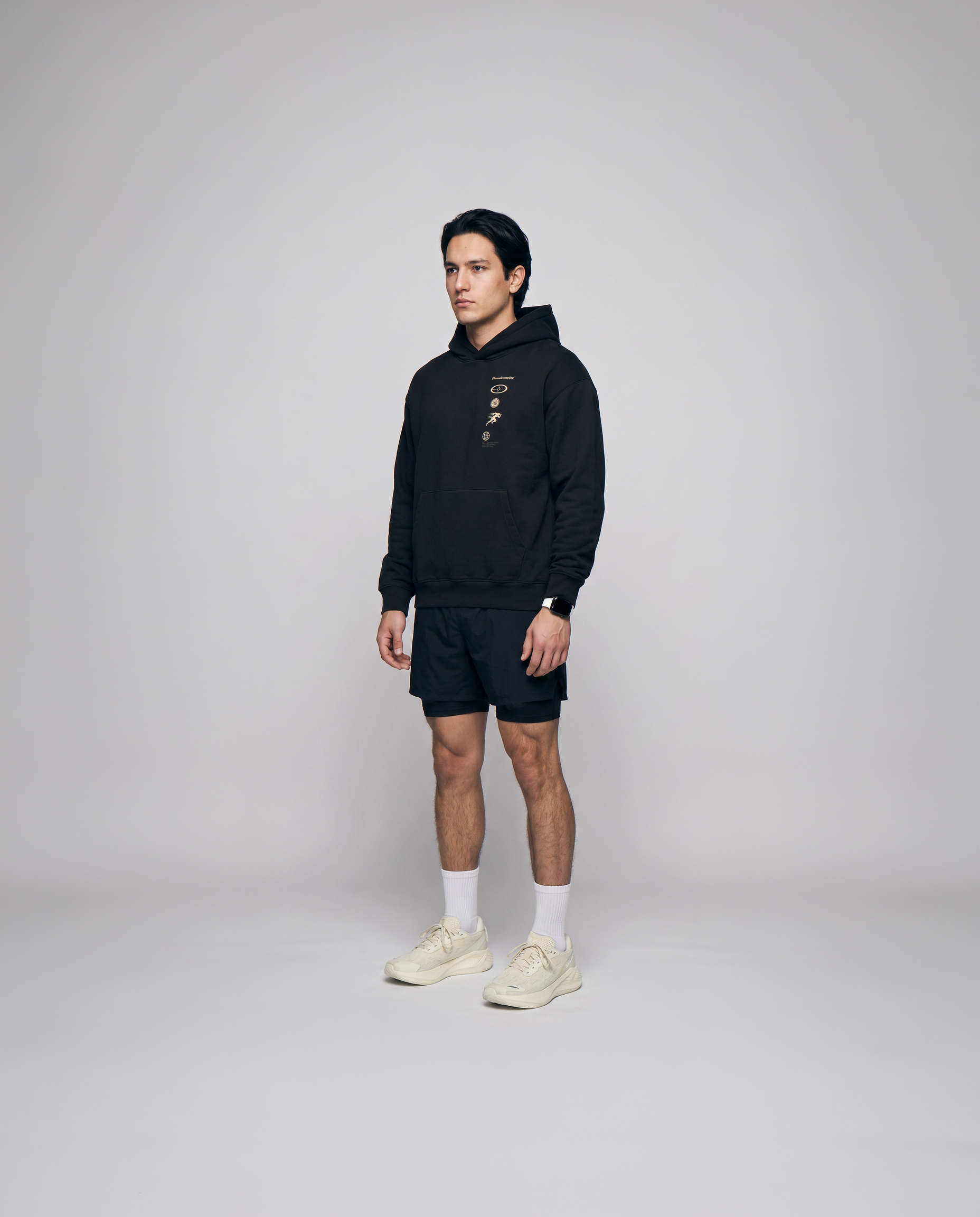 Model wearing the Strong Enough to Run oversize hoodie in black — three-quarter view showing the relaxed oversize fit
