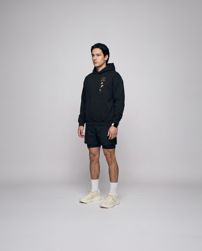 Model wearing the Strong Enough to Run oversize hoodie in black — three-quarter view showing the relaxed oversize fit