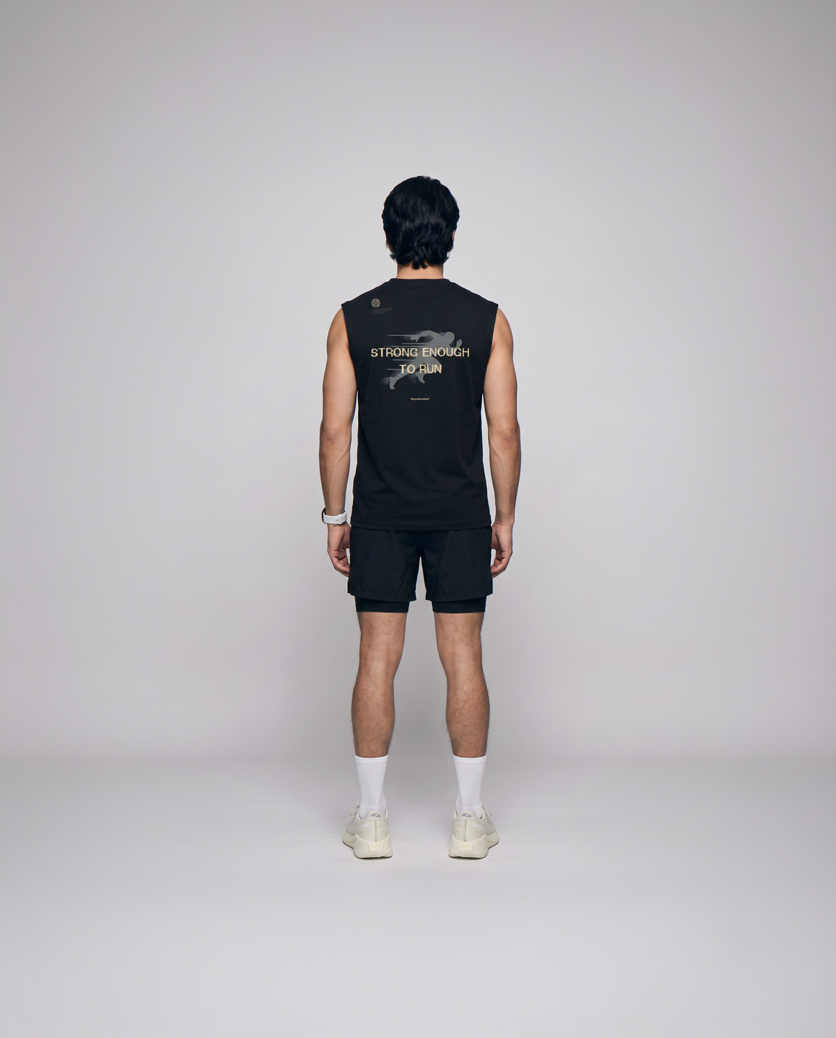 Model wearing the Strong Enough to Run tank top in black — back view with the STRONG ENOUGH TO RUN halftone runner print — View 3
