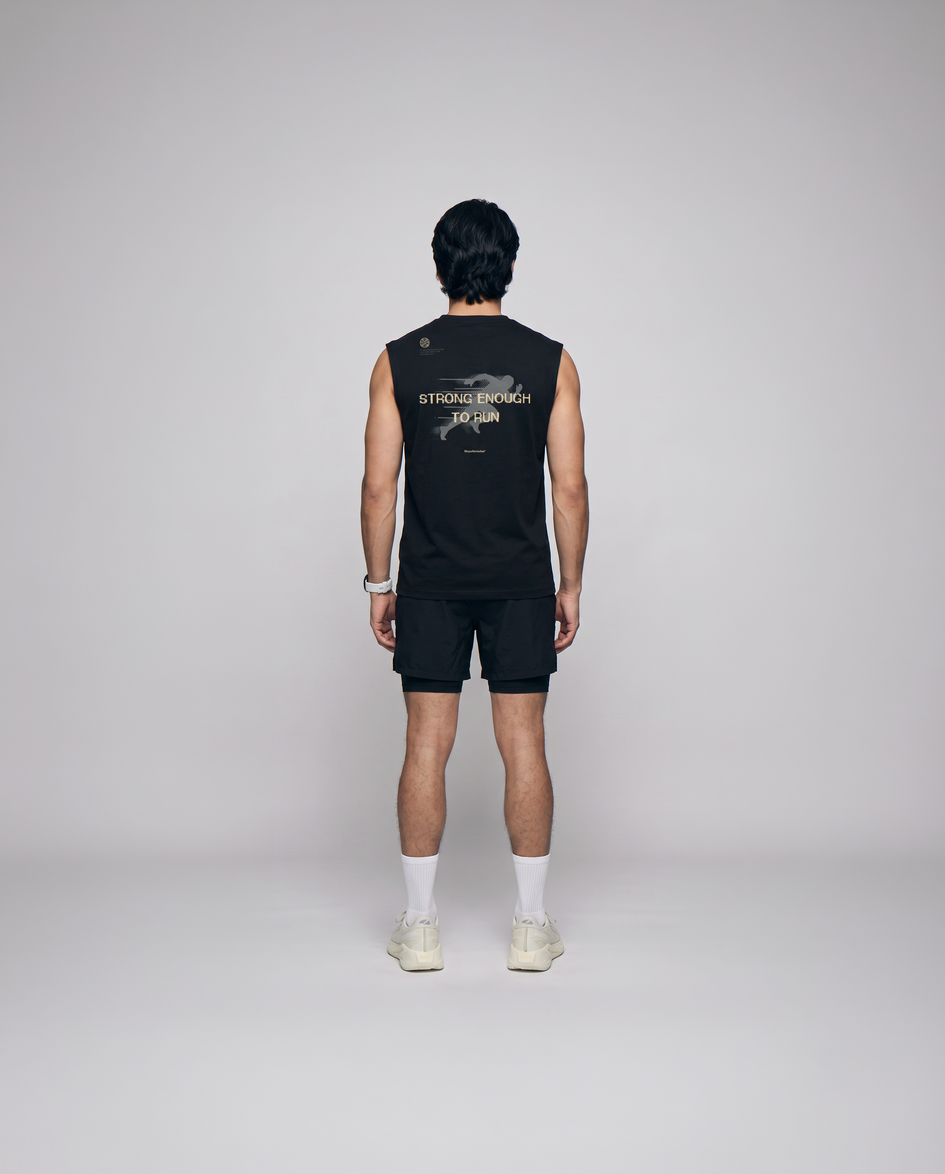 Model wearing the Strong Enough to Run tank top in black — back view with the STRONG ENOUGH TO RUN halftone runner print