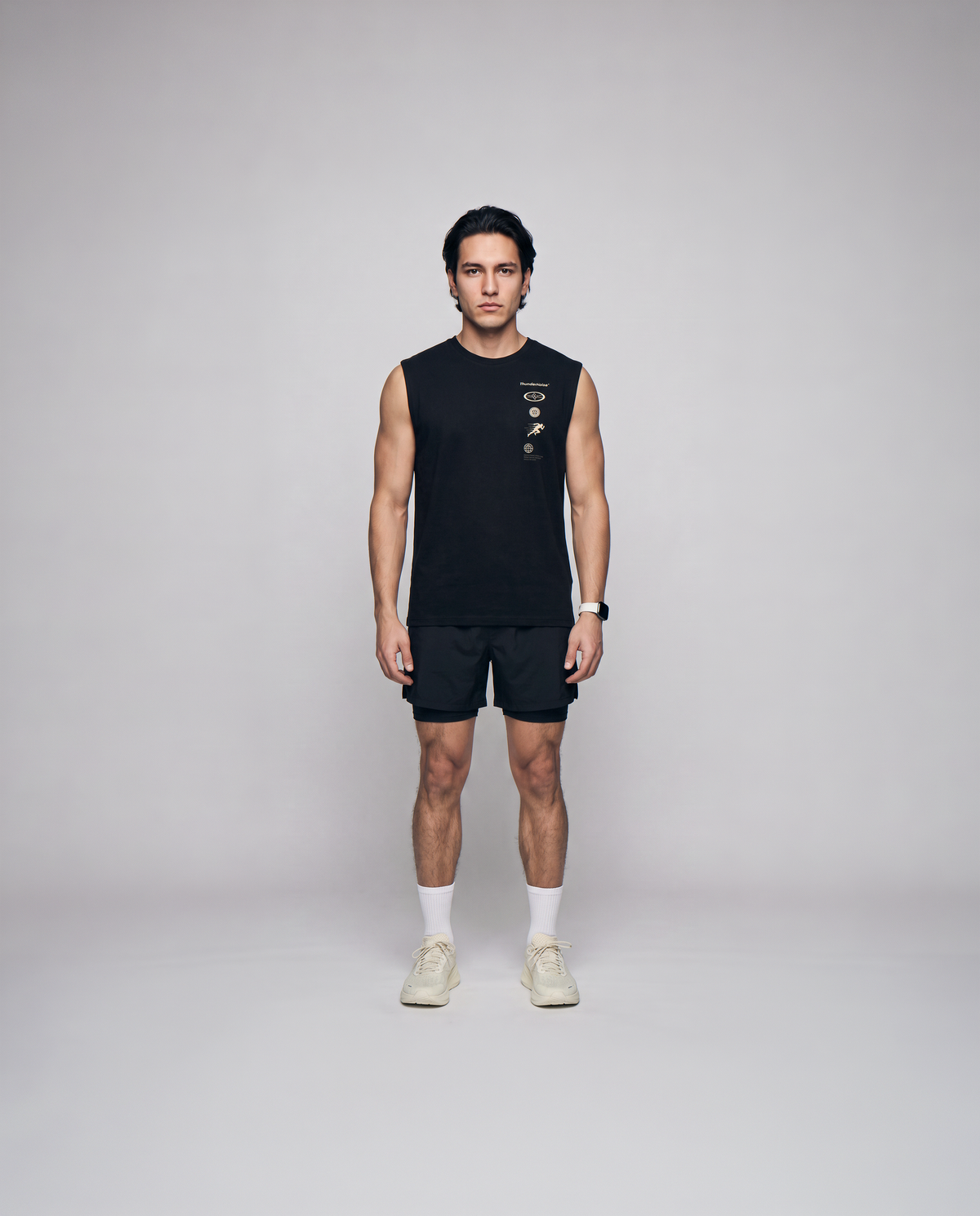 Model wearing the Strong Enough to Run tank top in black — front view with the right-chest marker column in sand and grey — View 4
