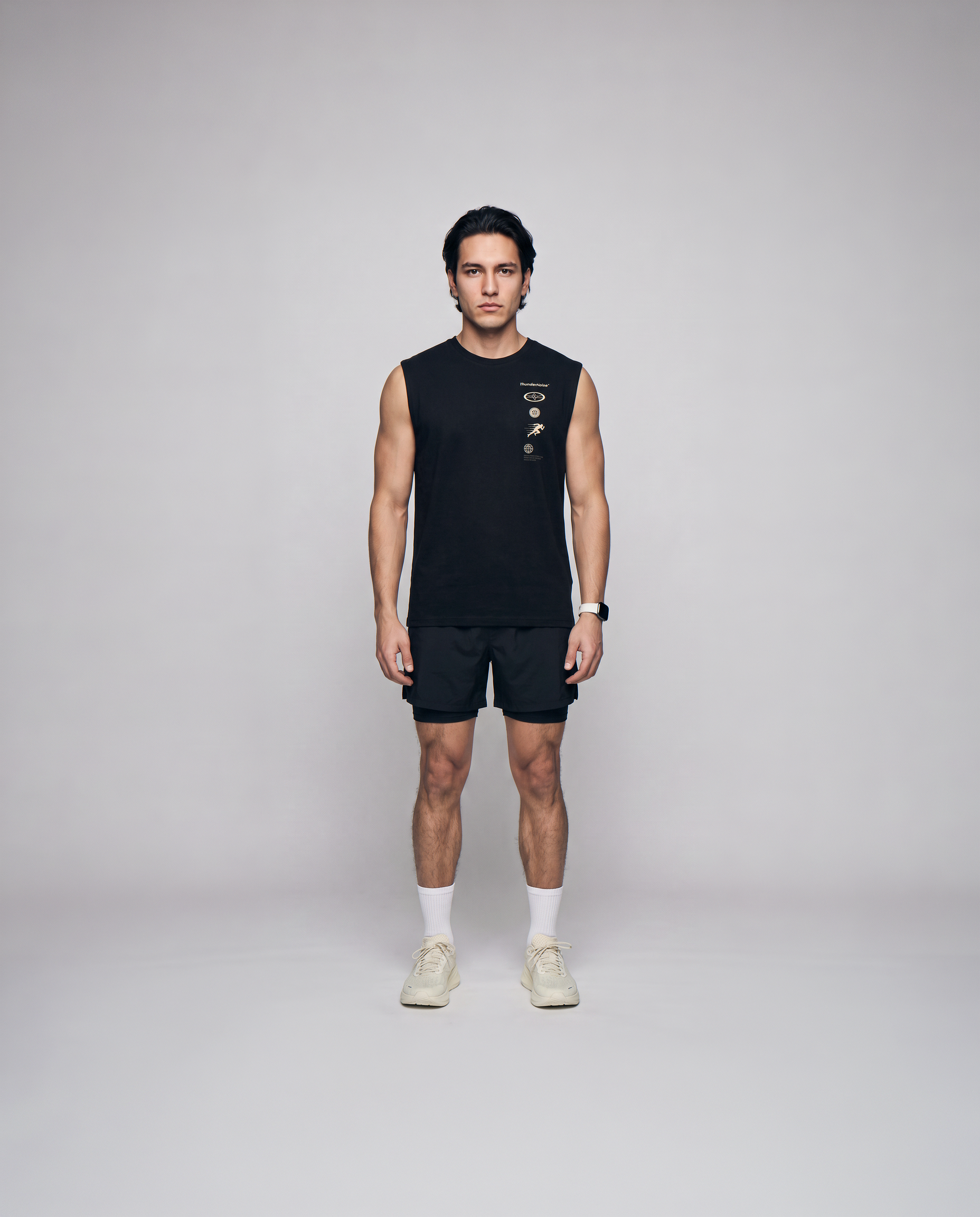 Model wearing the Strong Enough to Run tank top in black — front view with the right-chest marker column in sand and grey